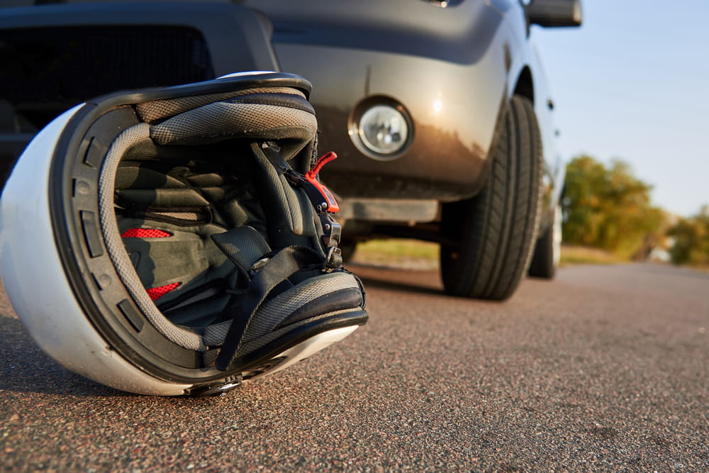 Damaged motorcycle helmet on the road after a crash