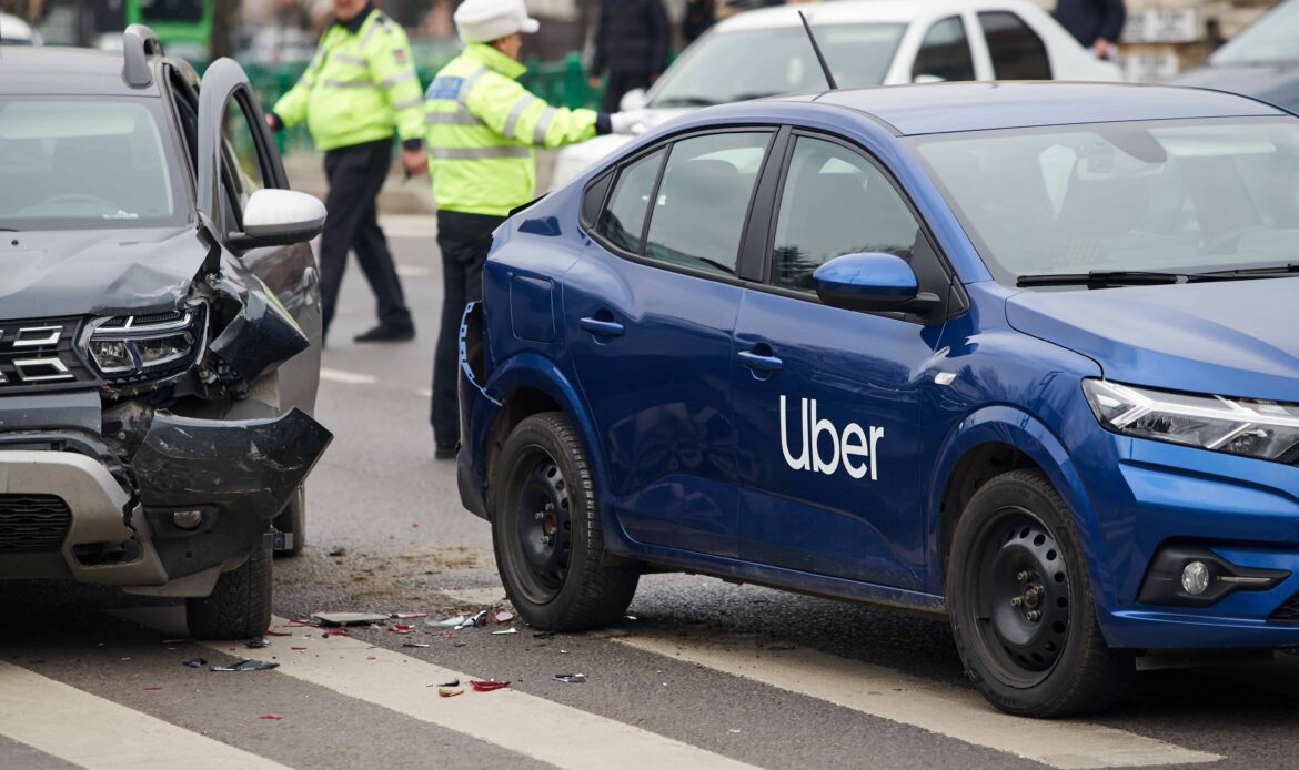 Uber car accident with another vehicle at city intersection as police officers investigate the scene.