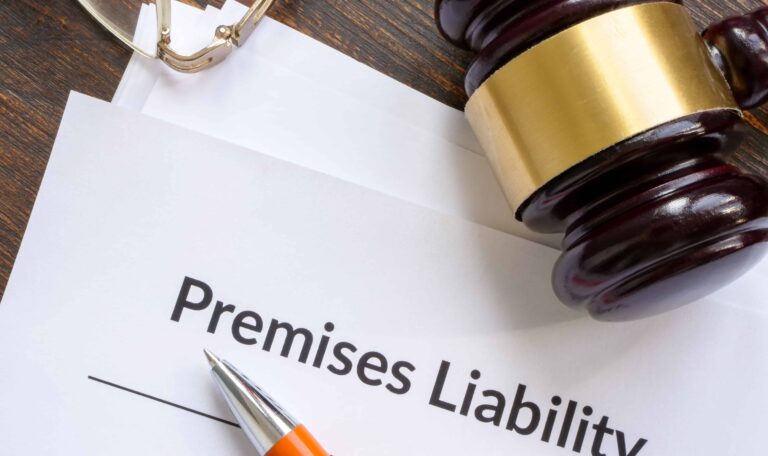 Premises liability legal document with gavel, pen, and glasses on wooden desk