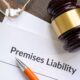Premises liability legal document with gavel, pen, and glasses on wooden desk