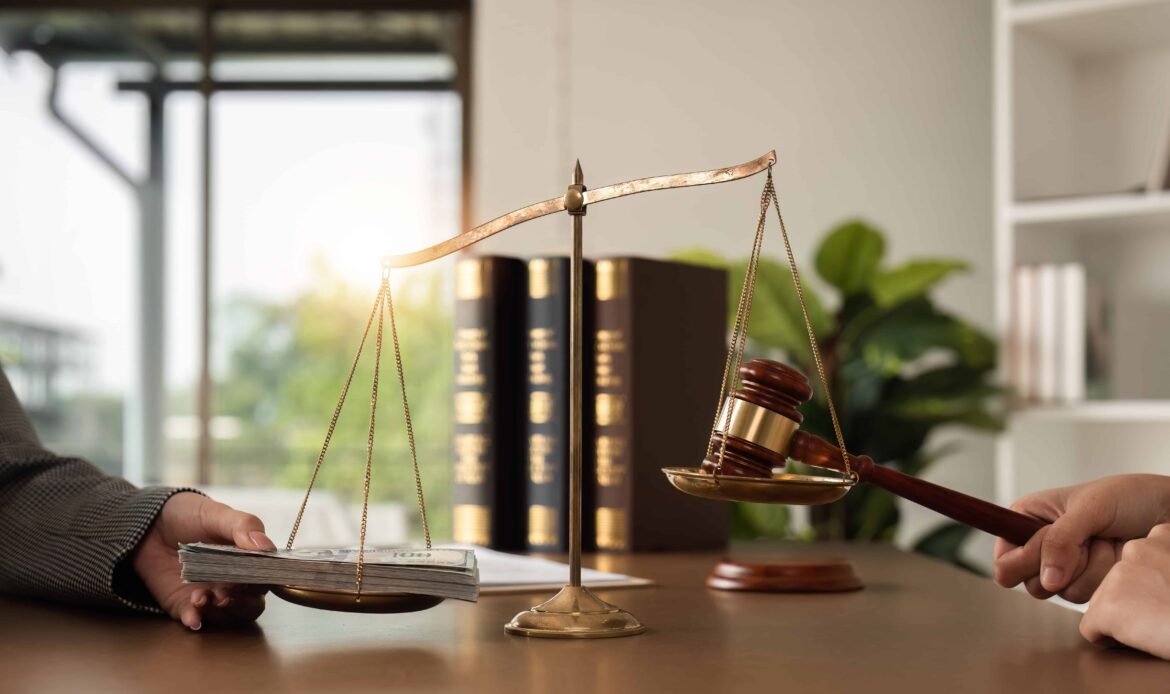 Scales of justice balancing gavel and money stack symbolizing legal judgment and financial settlement in law. Scales of justice balancing gavel and money stack symbolizing legal judgment and financial settlement in law.