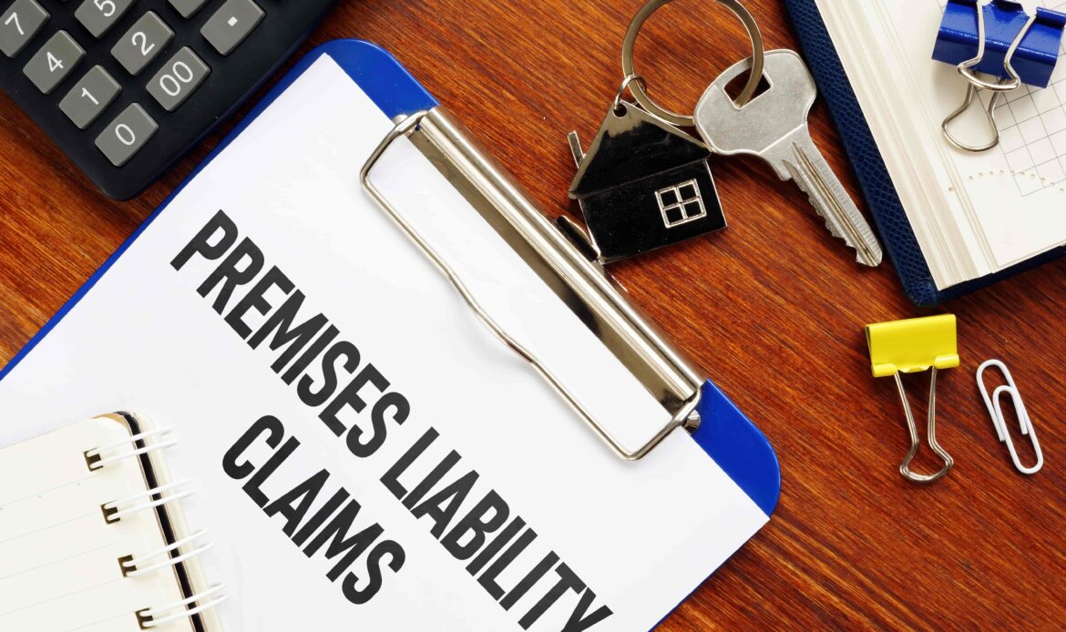 Premises liability claims document on clipboard with house key and office supplies on desk. Premises liability claims document on clipboard with house key and office supplies on desk.