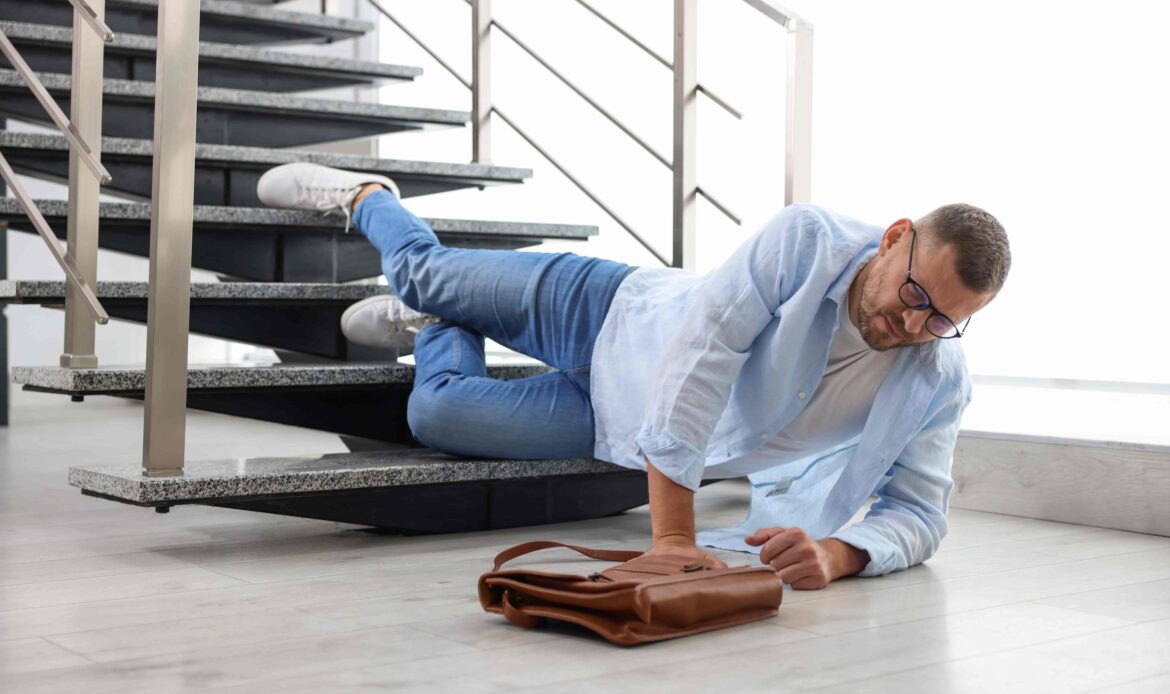 Man falling down stairs and injuring himself in an accident at work or public place.