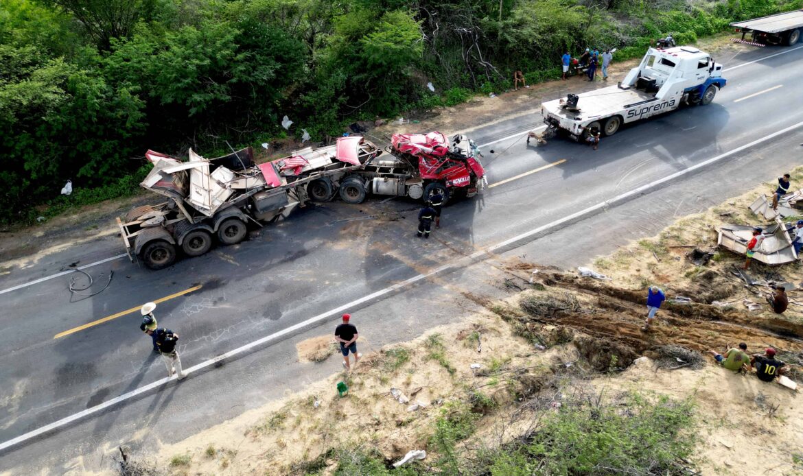 Aerial view of a serious semi-truck accident on a rural highway with emergency responders and tow trucks on scene.