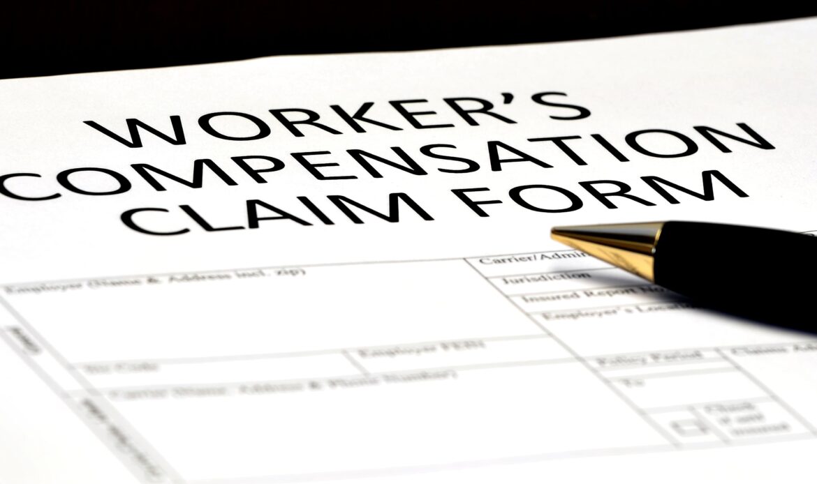 Worker’s compensation claim form with a pen on the desk, representing filing for workplace injury benefits. Worker’s compensation claim form with a pen on the desk, representing filing for workplace injury benefits.
