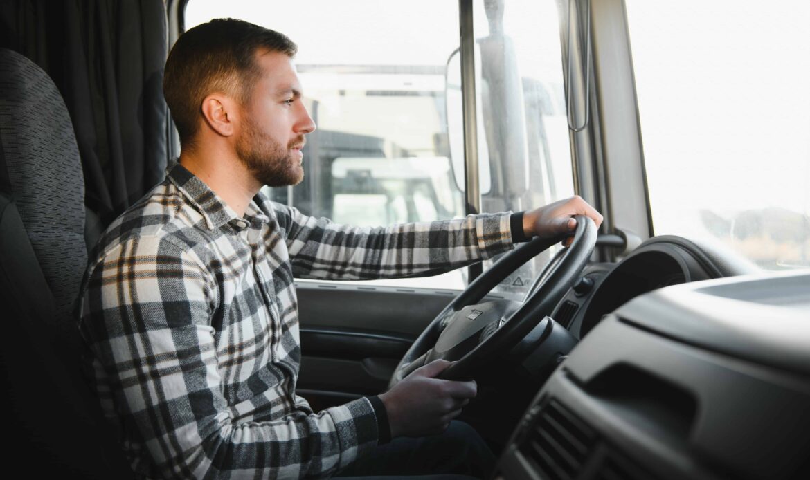 Truck driver sitting behind the wheel of a commercial vehicle, focused on the road and operating the truck safely. Truck driver sitting behind the wheel of a commercial vehicle, focused on the road and operating the truck safely.