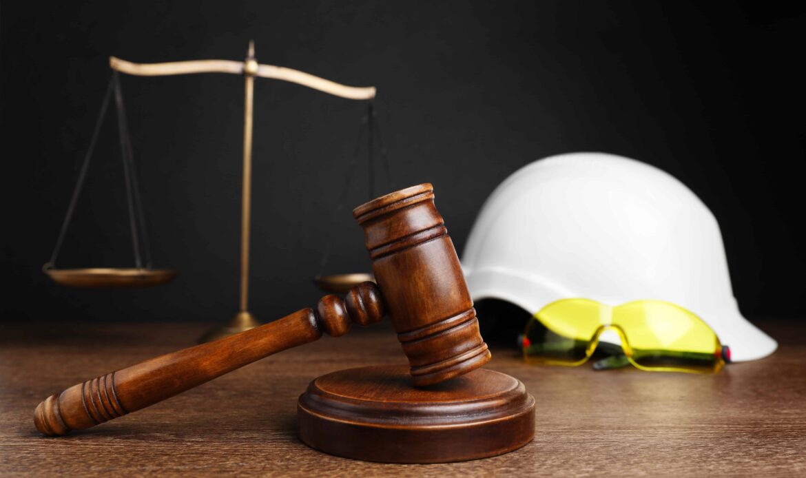 Judge’s gavel with justice scales, hard hat, and safety glasses symbolizing construction accident law and workplace injury cases. Judge’s gavel with justice scales, hard hat, and safety glasses symbolizing construction accident law and workplace injury cases.