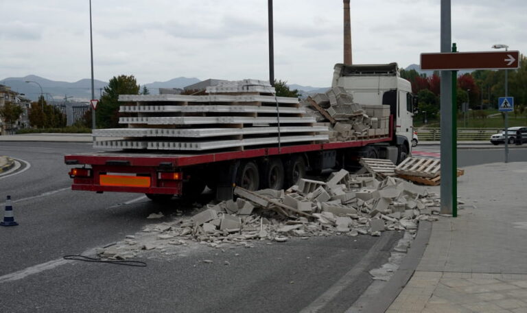Flatbed truck with improperly secured cargo spilled onto roadway after crash