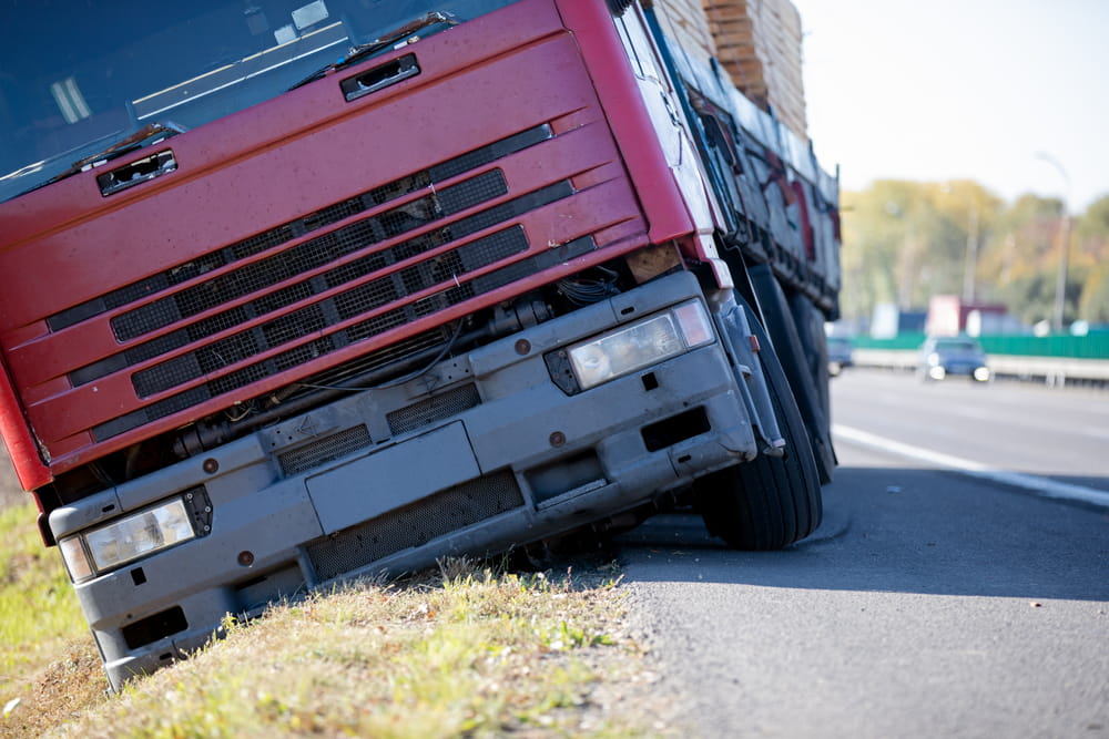 Commercial truck losing control on highway shoulder due to poor vehicle handling