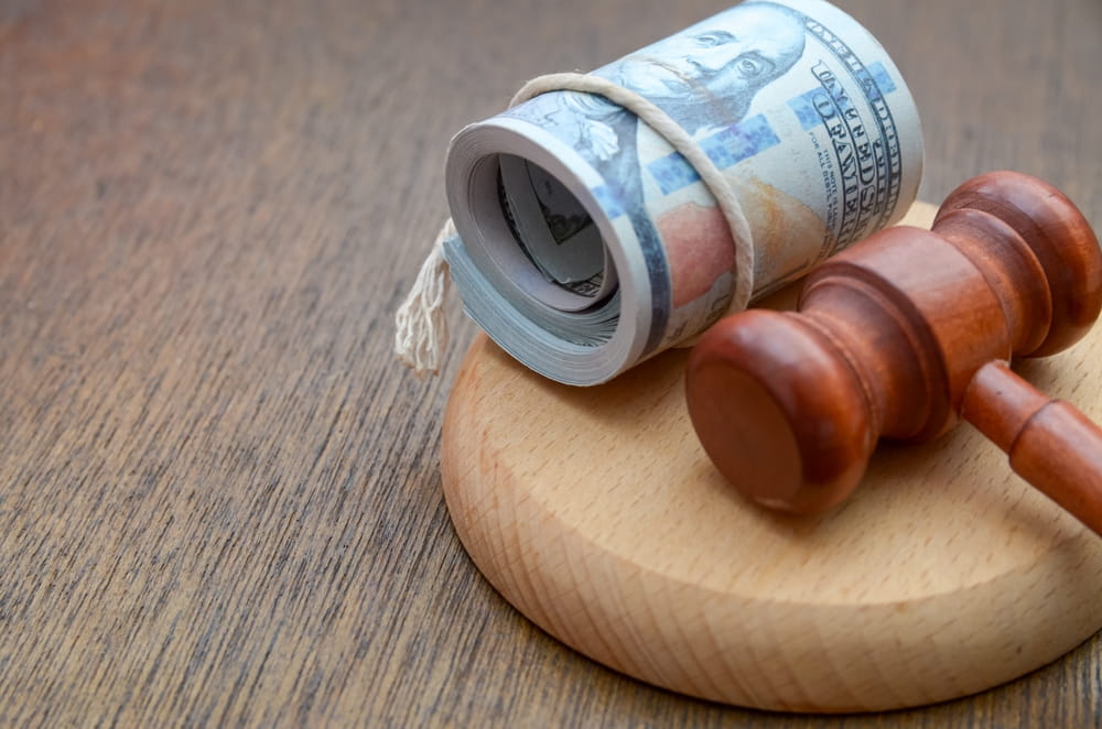 Court gavel and rolled cash representing personal injury settlement compensation