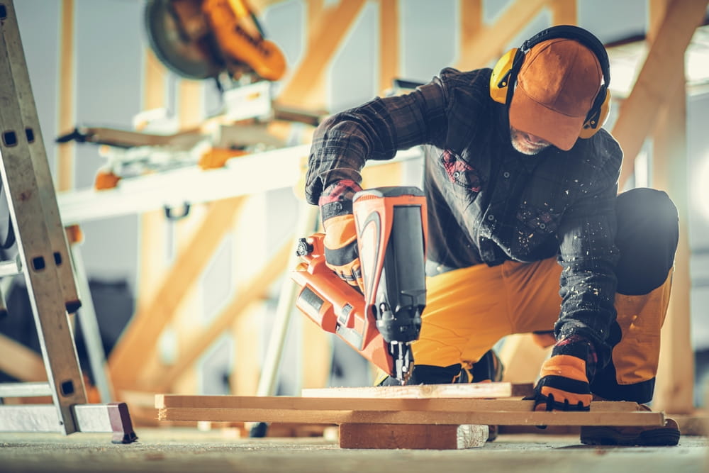 Construction worker using nail gun representing tool-related liability in Austin construction accident
