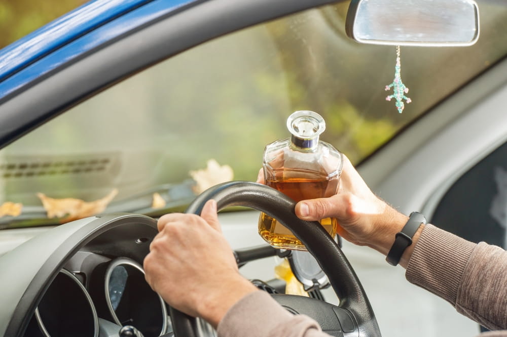 Driver holding alcohol while driving showing potential bar or restaurant liability in Colorado