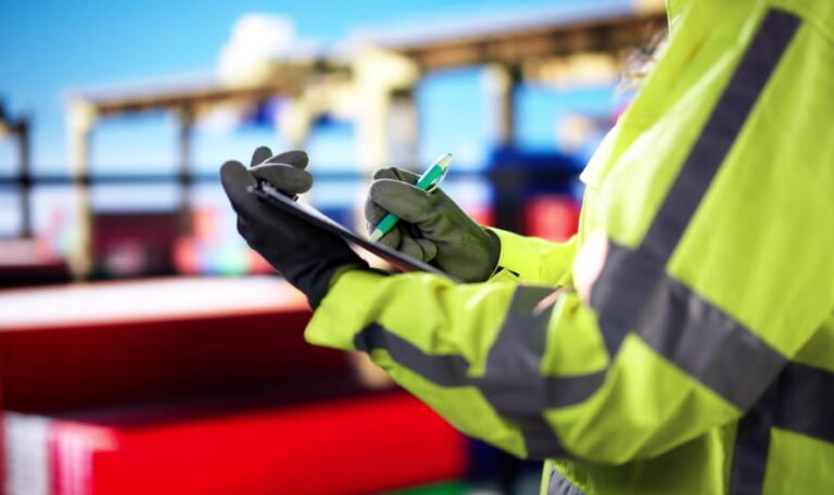 Worker conducting a safety inspection at a construction site, checking compliance with OSHA regulations to prevent accidents