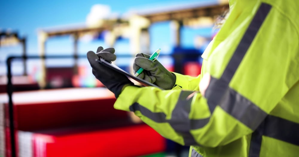 Worker conducting a safety inspection at a construction site, checking compliance with OSHA regulations to prevent accidents