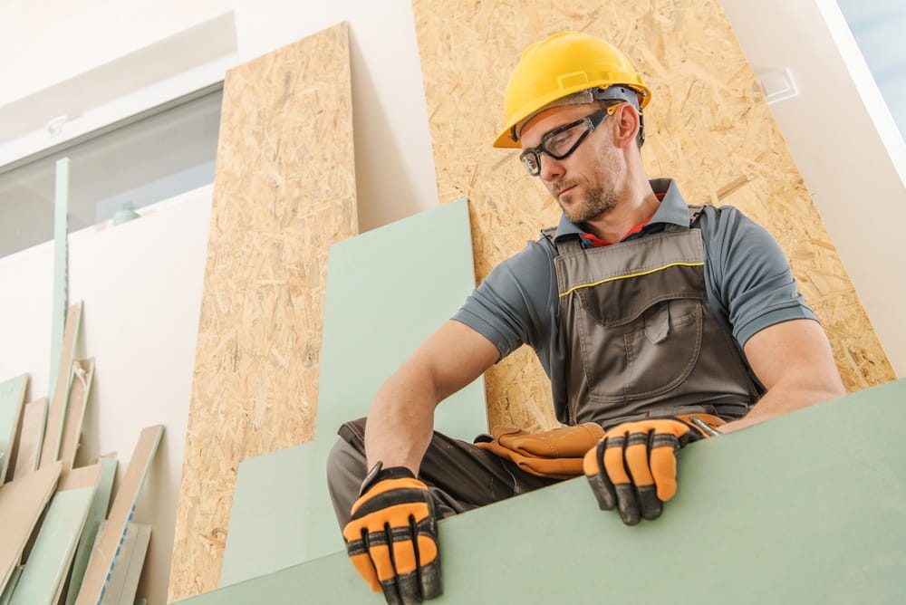 Construction worker handling materials on a job site, illustrating potential injury risks and OSHA safety requirements