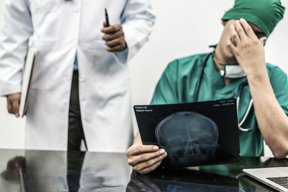 Doctor reviewing X-ray with concern, representing potential misdiagnosis or medical error in a Texas malpractice case