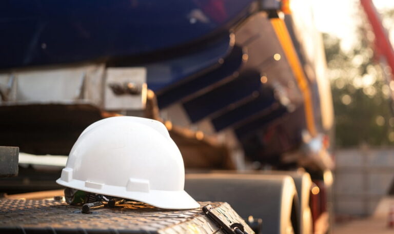 Hard hat near heavy equipment illustrating struck-by hazards on construction sites