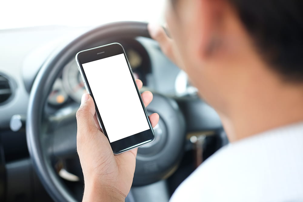 Rideshare driver checking a phone app while driving