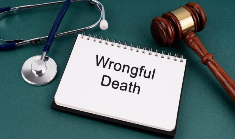 Wrongful death notepad beside a gavel and stethoscope representing a Colorado wrongful death damages claim