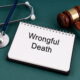 Wrongful death notepad beside a gavel and stethoscope representing a Colorado wrongful death damages claim