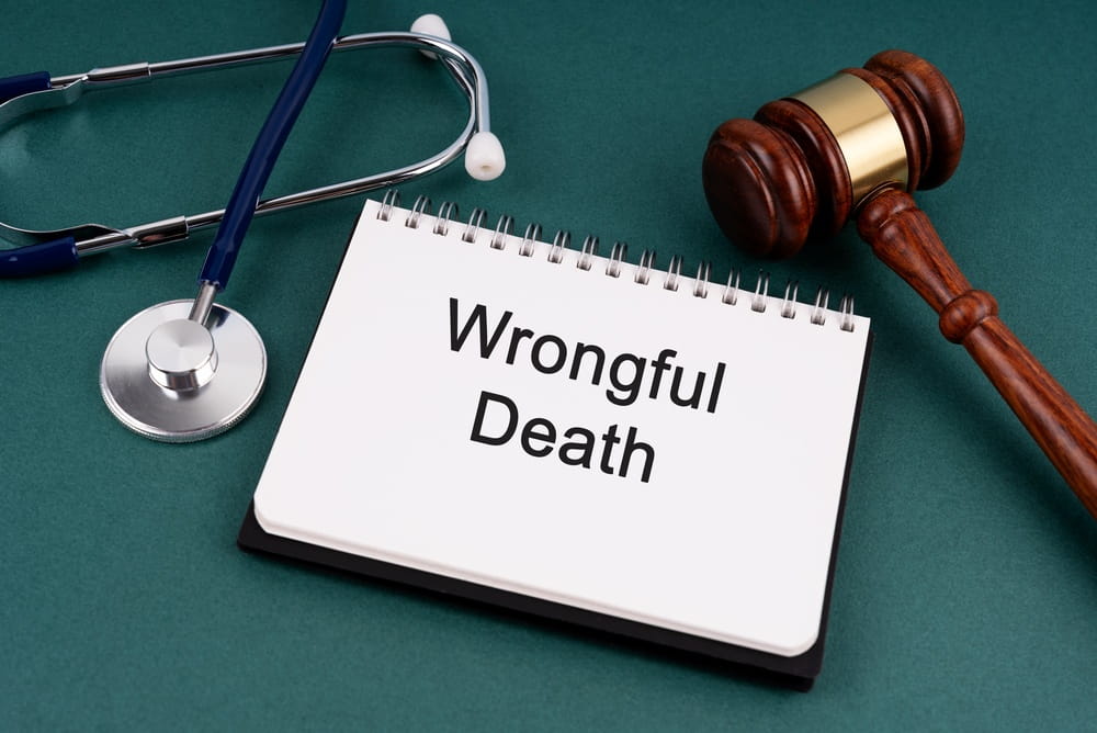 Wrongful death notepad beside a gavel and stethoscope representing a Colorado wrongful death damages claim