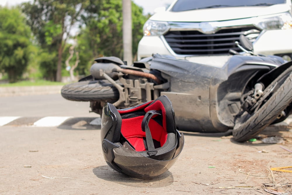 Motorcycle helmet beside a wrecked bike and car after a Grand Junction motorcycle accident