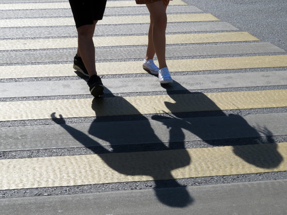 Pedestrians crossing in a marked crosswalk, illustrating Colorado's right-of-way rules