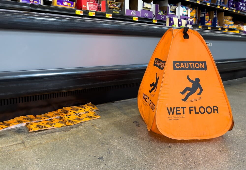 Wet floor warning sign near a grocery store hazard that could contribute to a slip-and-fall accident