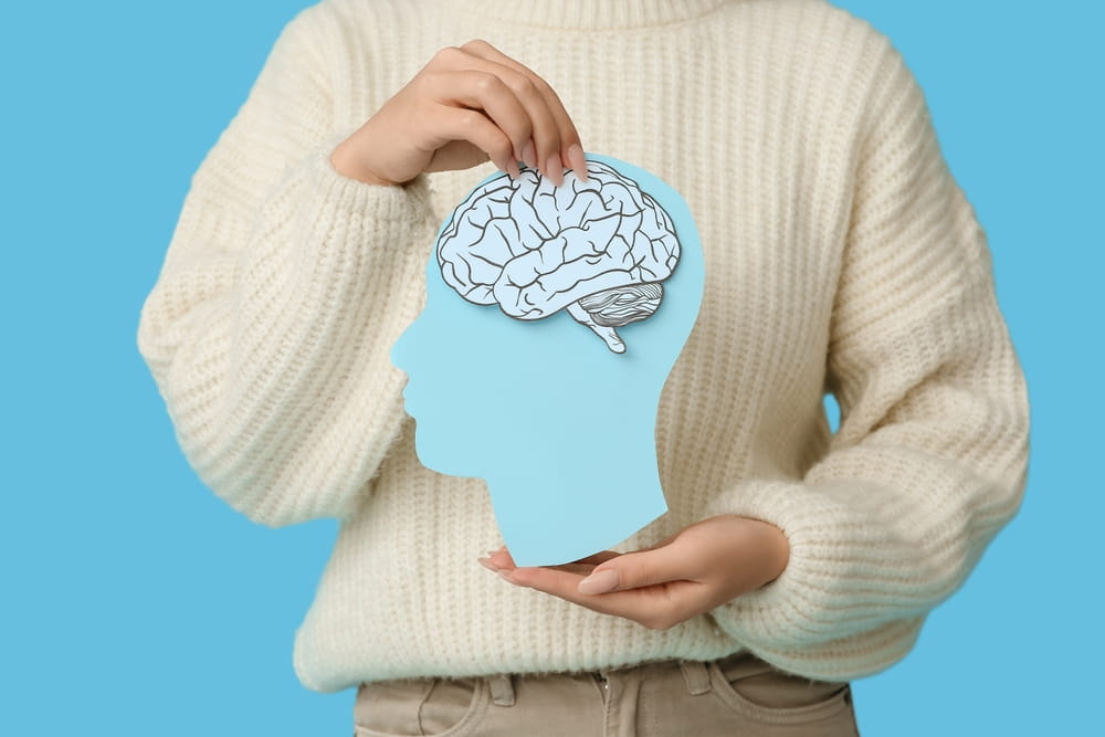 Person holding a brain illustration representing a mild traumatic brain injury after a car accident