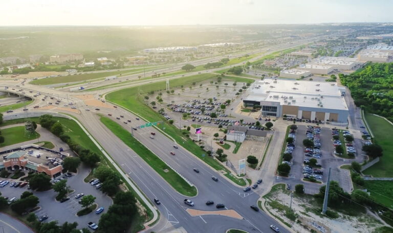 Aerial view of a highway interchange near commercial development in the Pflugerville area