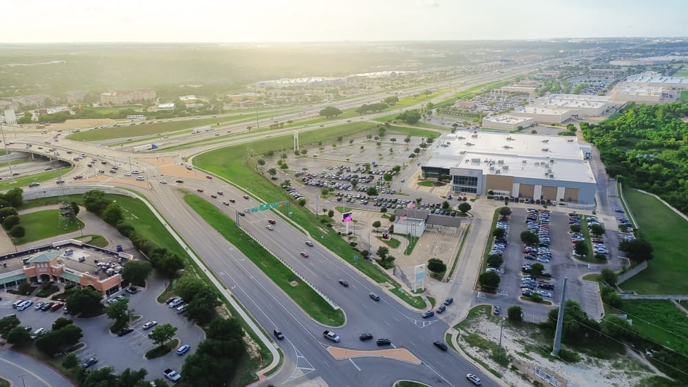 Aerial view of a highway interchange near commercial development in the Pflugerville area