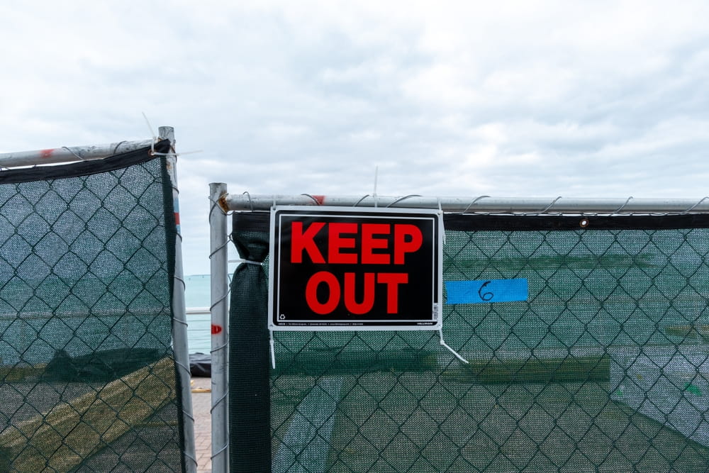 Keep Out sign on a fenced property illustrating trespasser status under Colorado premises liability law