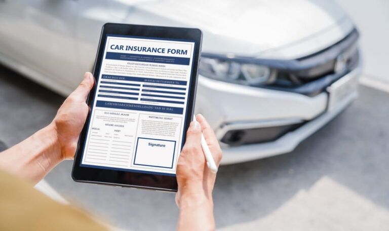 Person filling out a car insurance claim form on a tablet after an accident