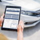 Person filling out a car insurance claim form on a tablet after an accident