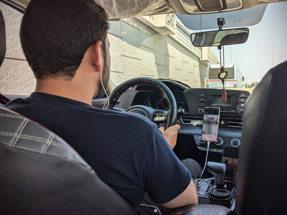 Rideshare Driver Using Mobile App Rideshare driver with phone mounted on the dashboard during a trip