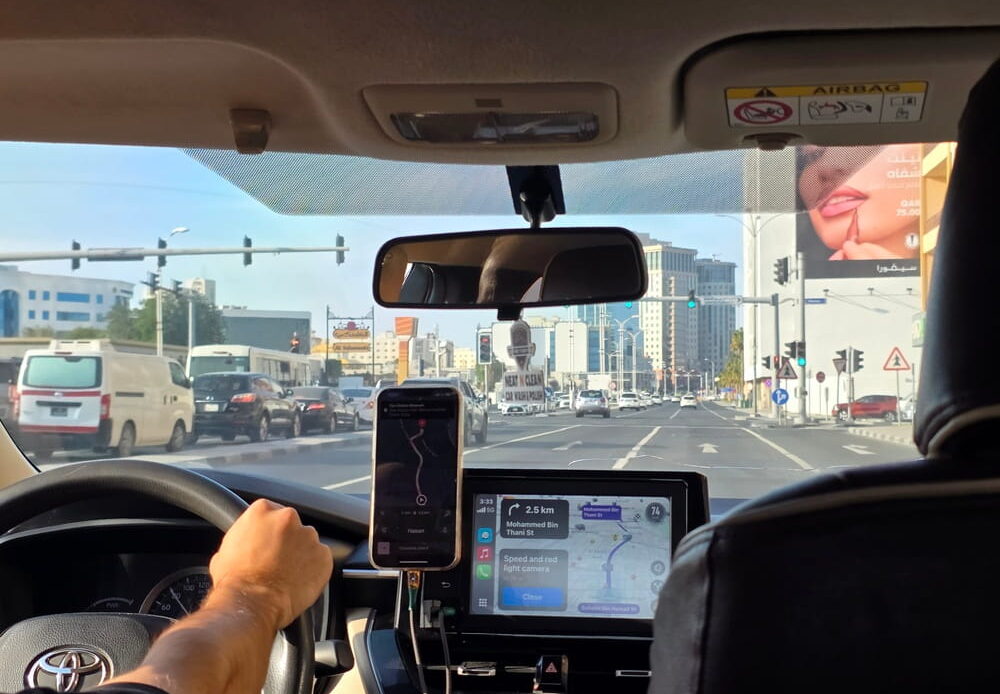 Rideshare driver's view through the windshield with navigation app open