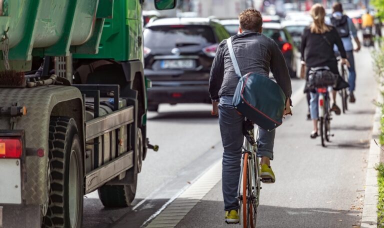 Cyclist riding in a marked bike lane alongside traffic in Austin, Texas